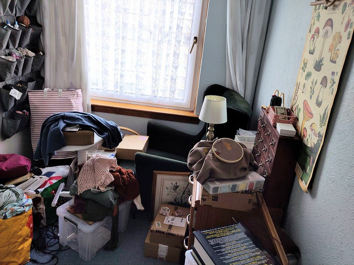 two pictures of a small studio room. The left picture shows a desk with a sewing machine and art materials. The right picture shows a green chair in the corner near a window next to boxes, a bookshelf, and art supplies.