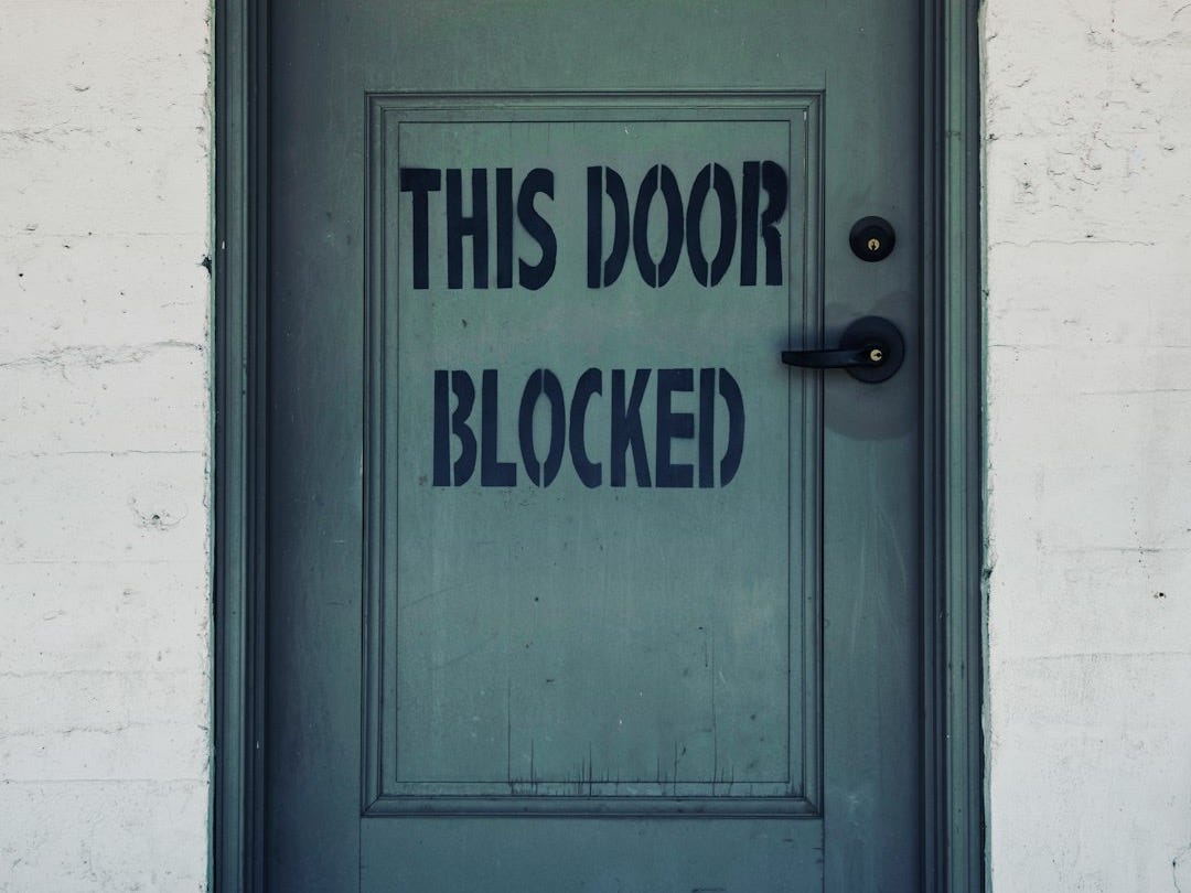 blue wooden door with white concrete wall