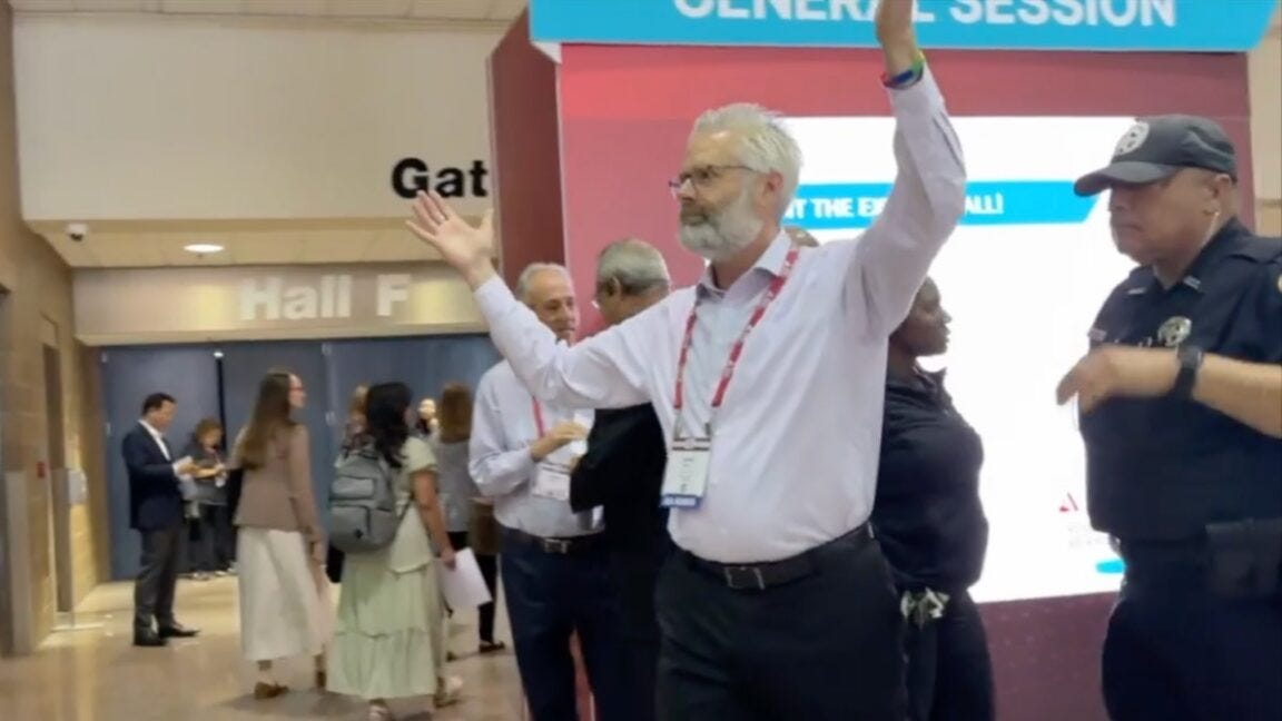 Police escort Dr. Steven Kahn out of a medical conference in New Orleans for handling out copies Police escort Dr. Steven Kahn out of a medical conference in New Orleans for handling out copies