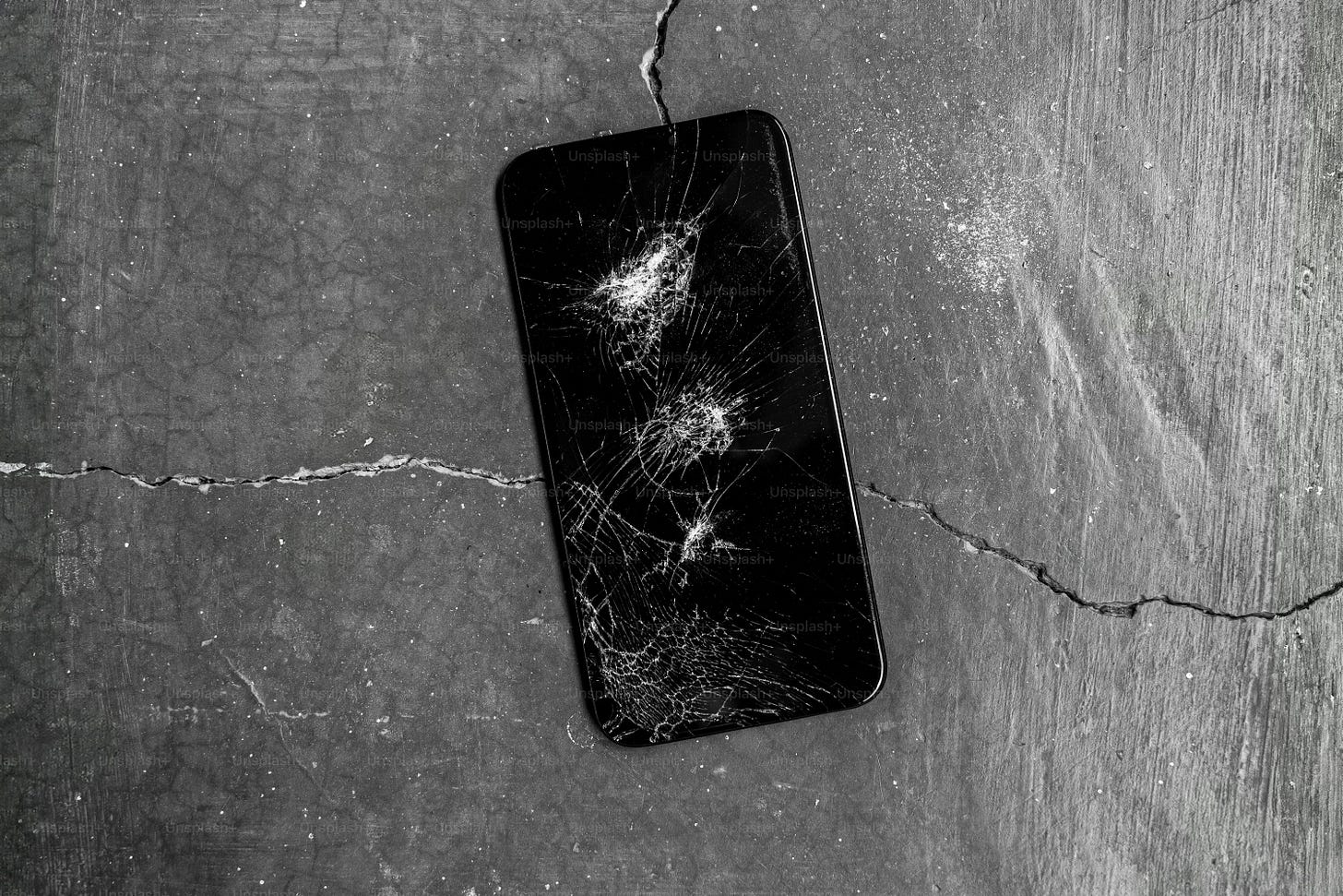 A black and white photo of a broken cell phone