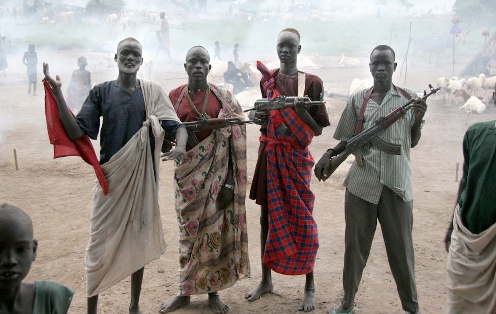 four men holding assault rifles