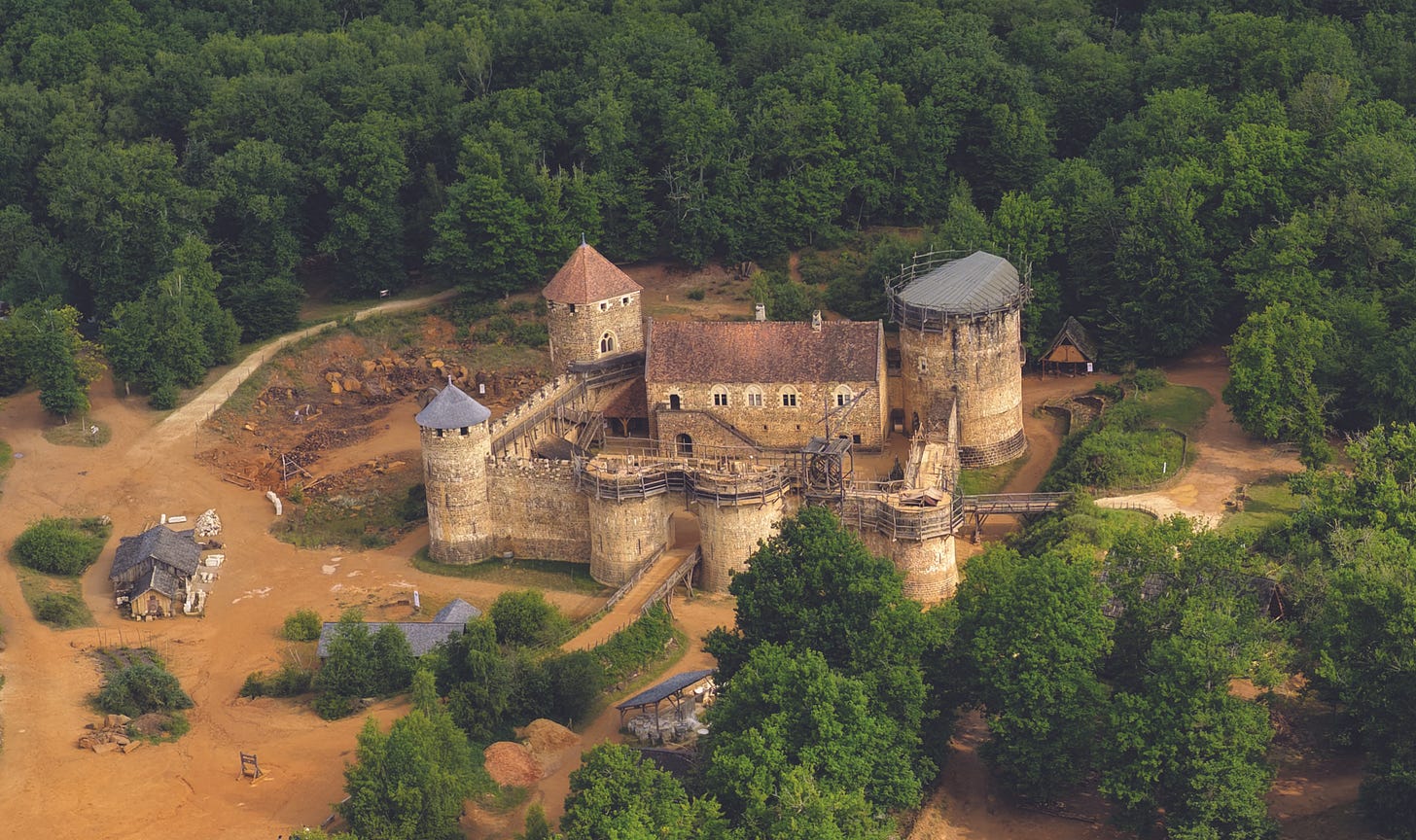 Aerial view of Guédelon Castle surrounded by forest. Aerial view of Guédelon Castle surrounded by forest.
