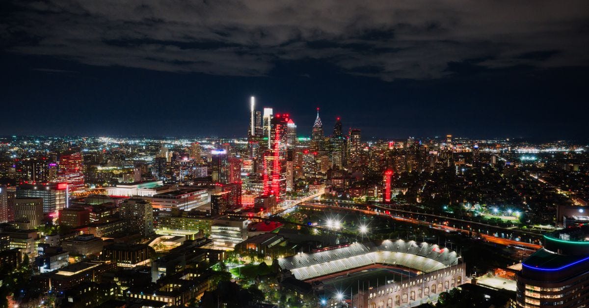 Photo: K / Pexels A breathtaking aerial view of Philadelphia's illuminated skyline at night, highlighting the vibrant cityscape and a prominent stadium.