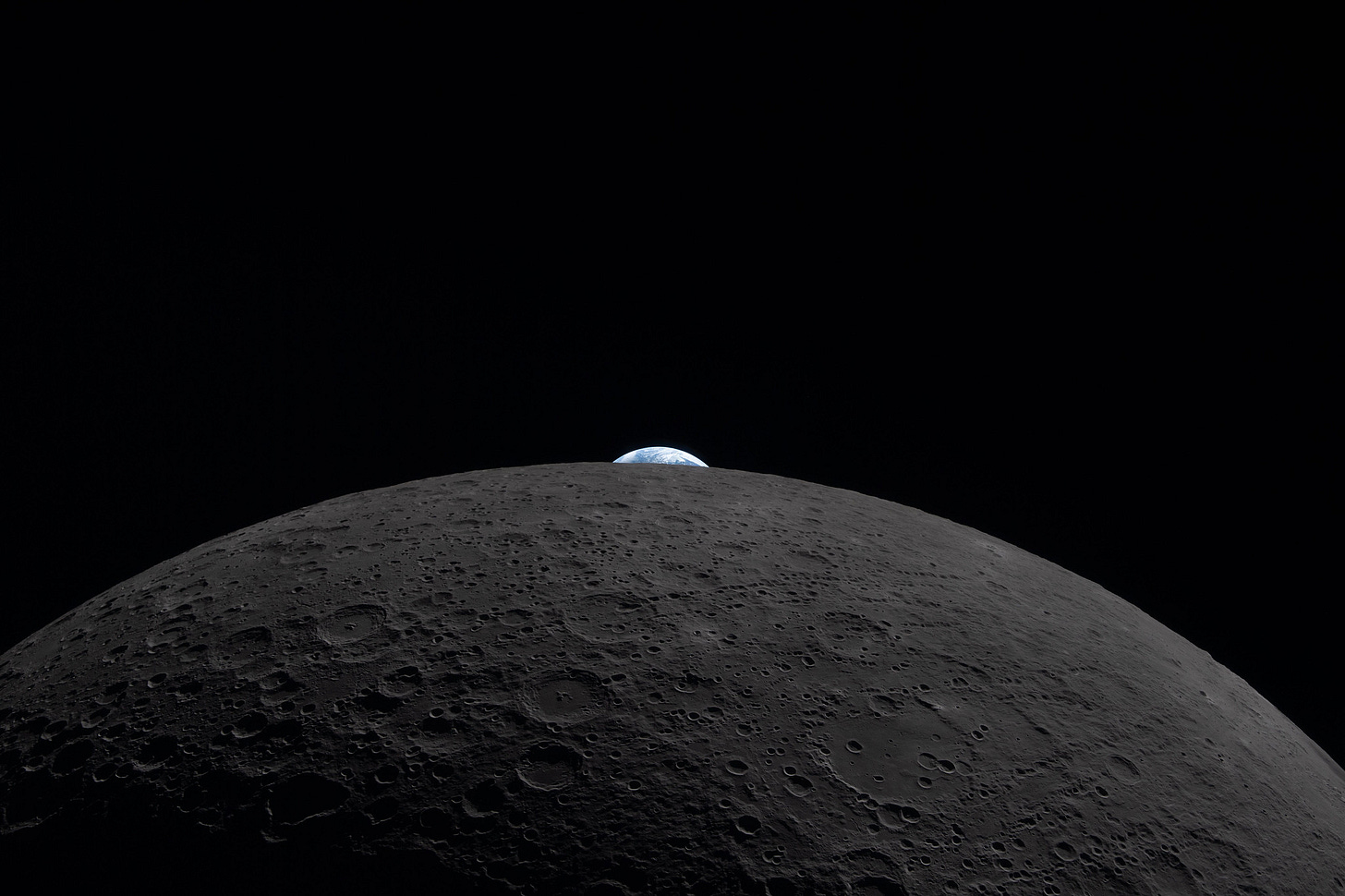 The Earth appears to be peeking out over the horizon of the Moon,but pictured here is actually an Earthset. During an Earthset, the planet appears to sink below the lunar horizon. In this scene, a partially lit crescent Earth drops behind the Moon as seen by crew on the Orion spacecraft. The image also shows the vast canvas of the Moon’s surface with its overlapping craters and basins.