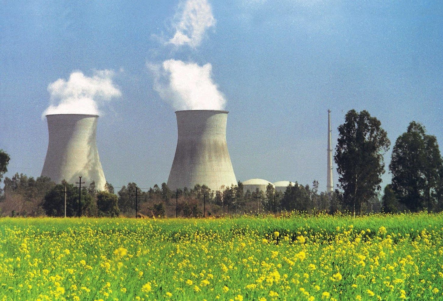 The image shows two large, tall smokestacks with plumes of smoke rising in a field of bright yellow flowers under a clear blue sky.
AI-generated content may be incorrect. The image shows two large, tall smokestacks with plumes of smoke rising in a field of bright yellow flowers under a clear blue sky.
AI-generated content may be incorrect.