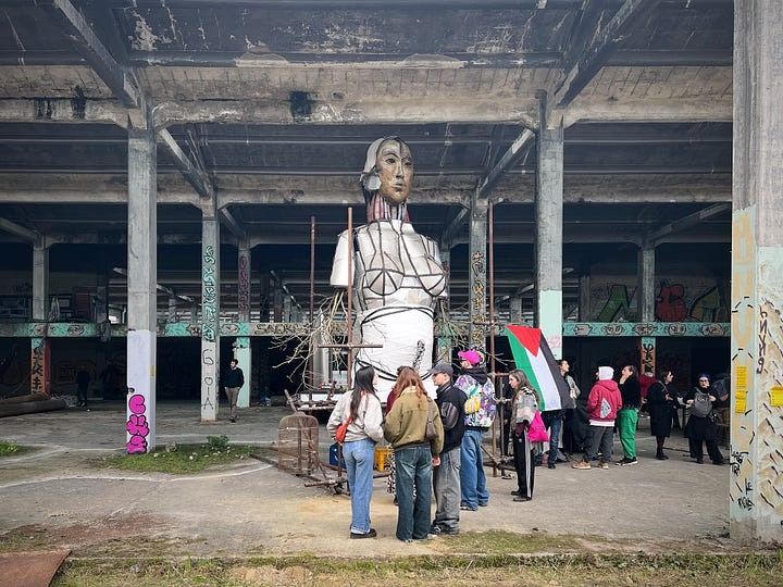 La scultura chiamata Venere Biomeccanica con una bandiera palestinese all'interno del capannone industriale abbandonato dell'ex -Meccanotessile di Rifredi circondata da attivisti e residenti del circondario, attività di laboratori pubblici di collage e cartografia collaborativa 