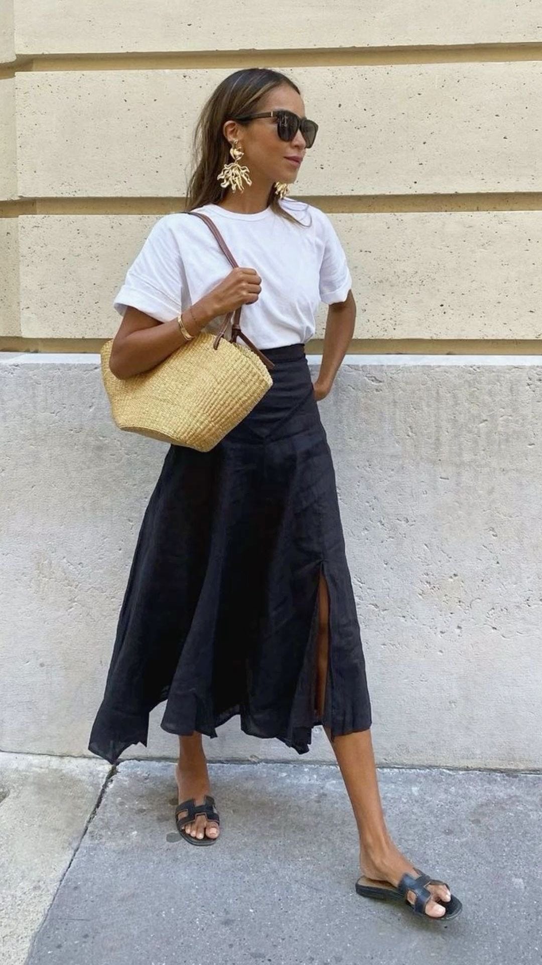 mujer con look de entretiempo con falda midi y camiseta sencilla
