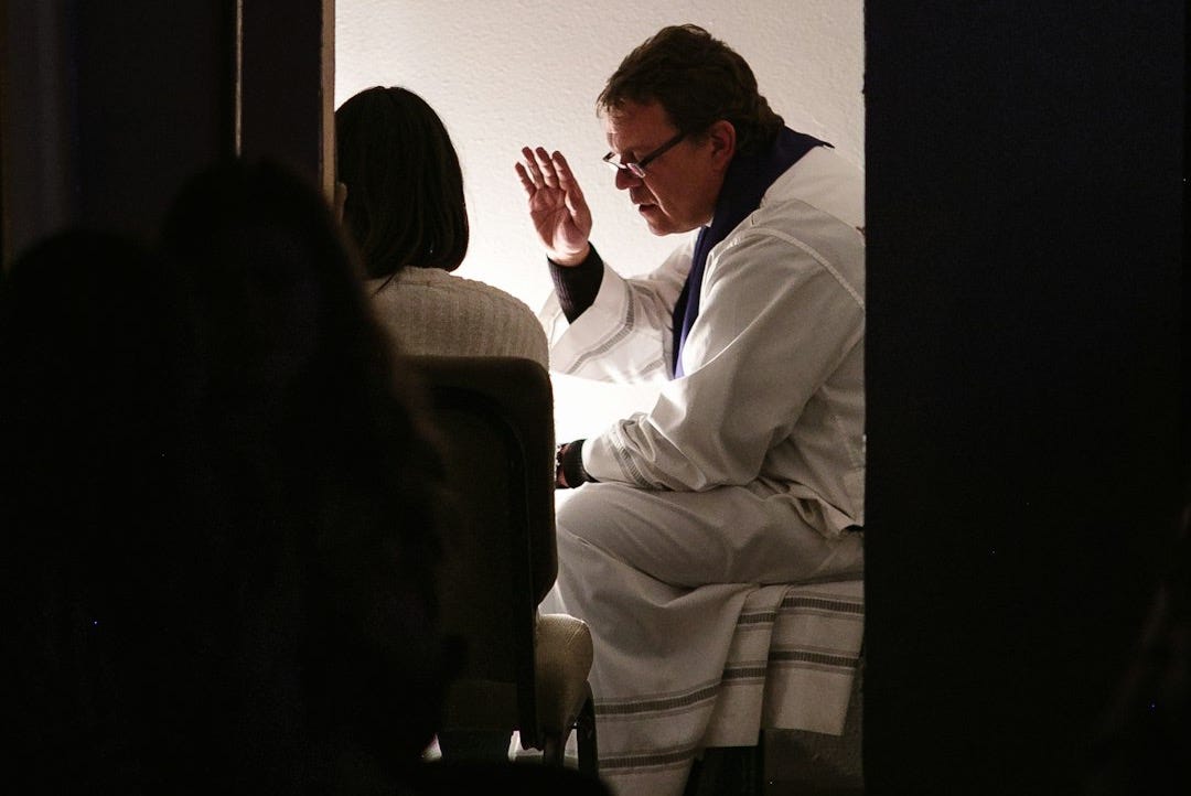 man wearing white bathrobe sitting on bed
