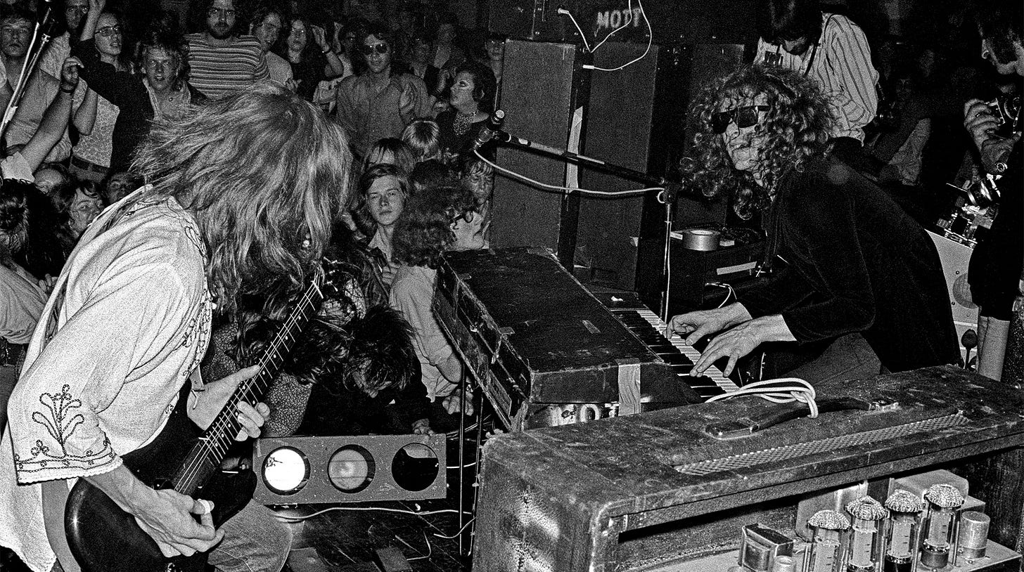 Mick Ralphs and Ian Hunter of Mott The Hoople perform on stage, with the audience cheering behind, at The Royal Albert Hall, London on July 8 1971. Mick Ralphs and Ian Hunter of Mott The Hoople perform on stage, with the audience cheering behind, at The Royal Albert Hall, London on July 8 1971.