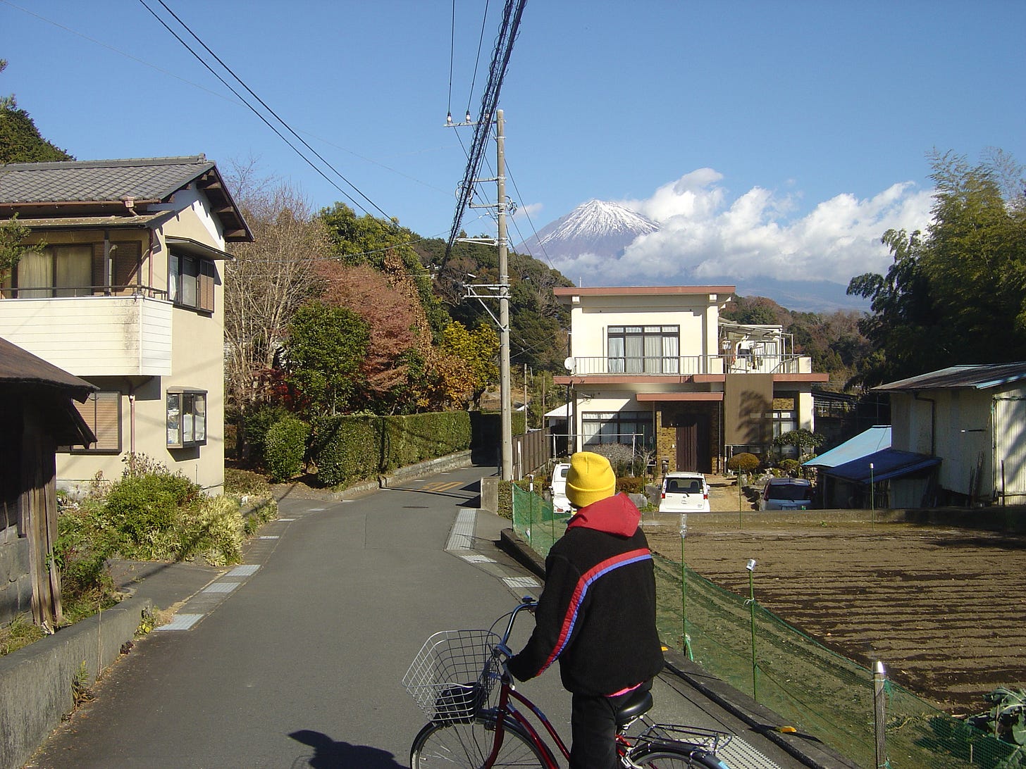 Theo looking at Mount Fuji from his bike, in the streets of Fujinomiya.