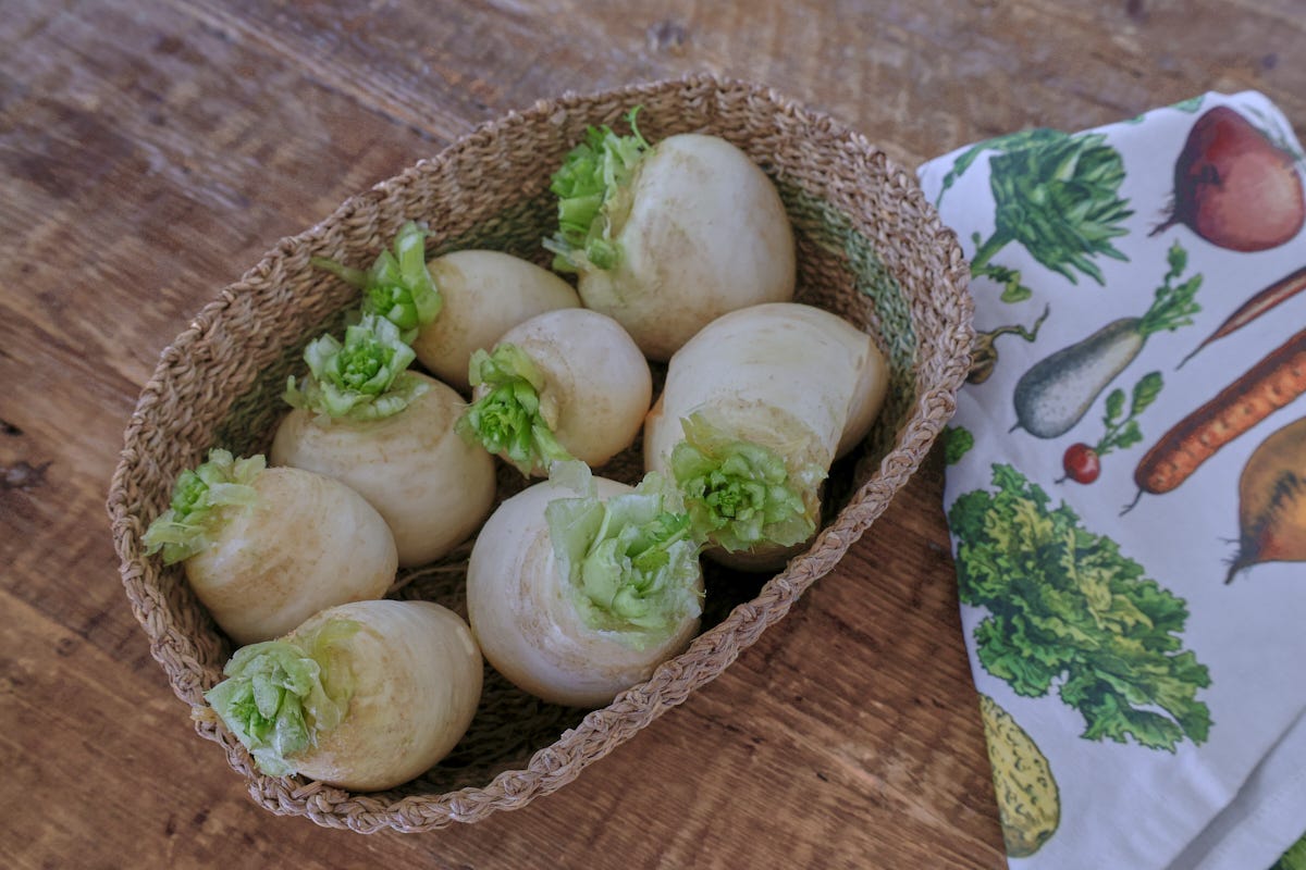 turnips in a basket with a kitchen towel alongside turnips in a basket with a kitchen towel alongside