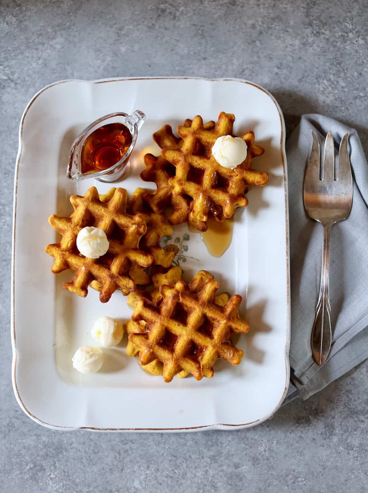 a white platter with pumpkin waffles. a white platter with pumpkin waffles.