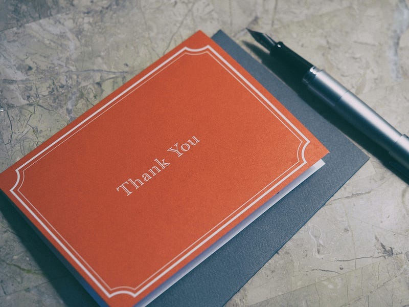 A thank-you note with a fountain pen next to it