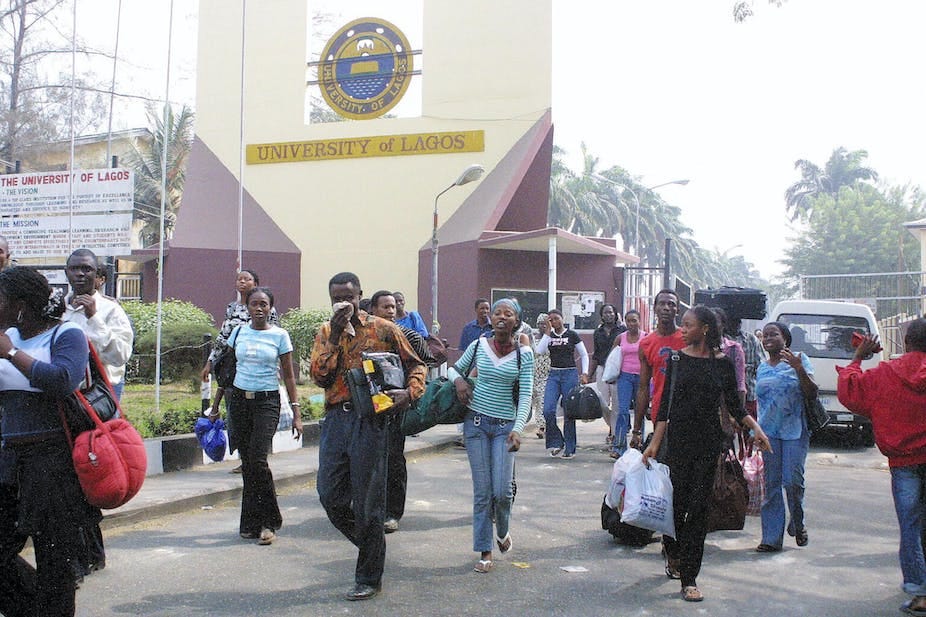 A group of young men and women carrying bags out of a university building. A group of young men and women carrying bags out of a university building.