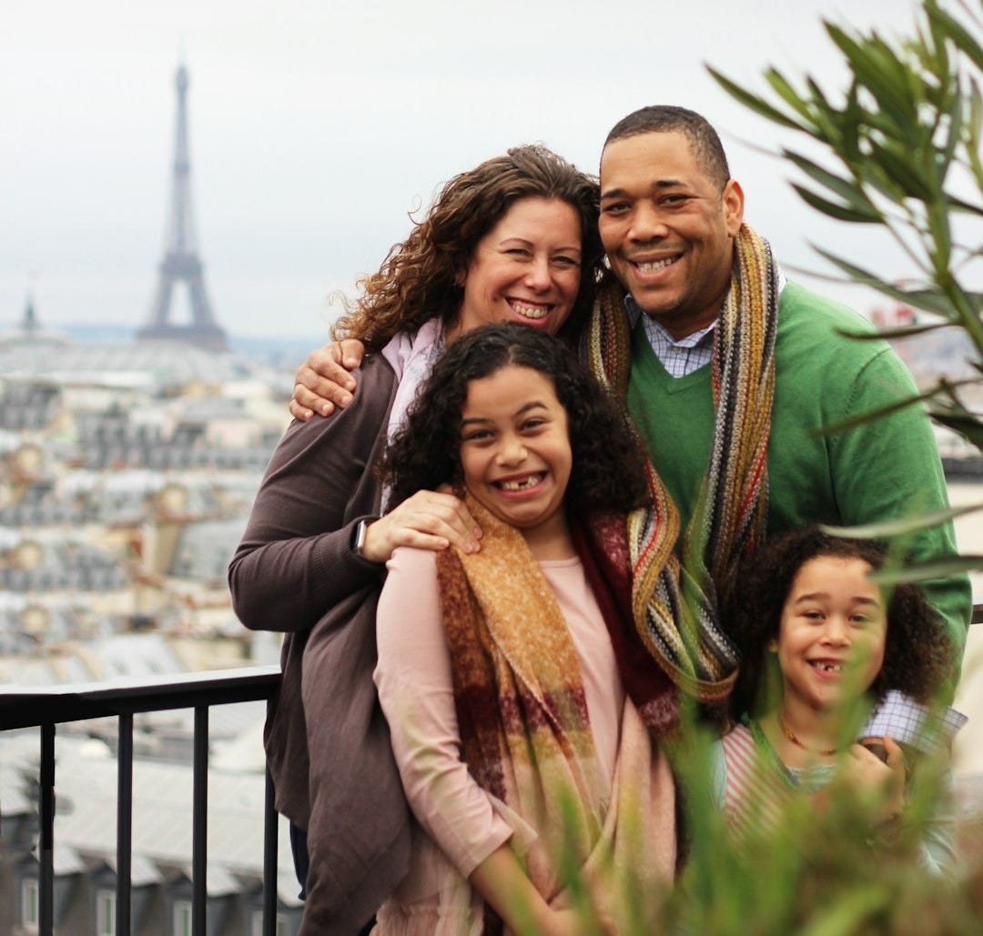 woman in black long sleeve shirt carrying girl in brown scarf