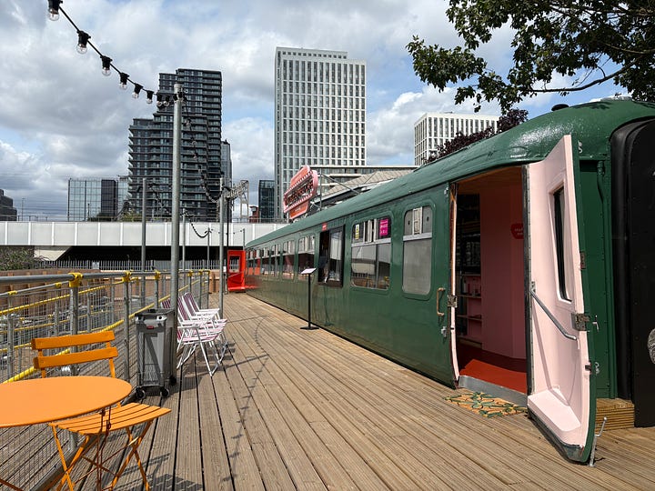 Different perspectives of the cafe inside an old railway carriage. There is a big wooden terrace.
