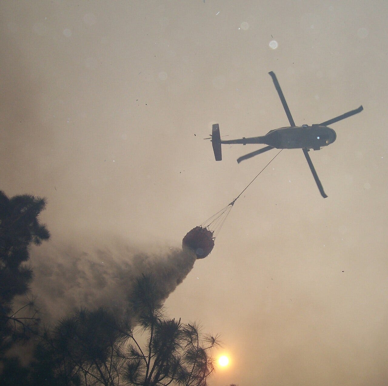 Photo: US Forest Service - Southern Region / Wikimedia Commons (Public domain) Through the trees, helicopter dropping water on a wildfire in the Ocoee Ranger District of the Cherokee NF.