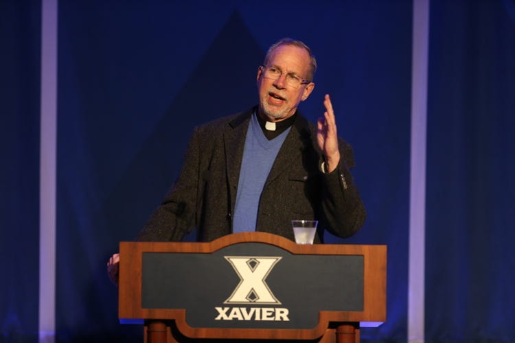 Rev. Michael J. Graham, S.J., speaking at a Xavier University podium Rev. Michael J. Graham, S.J., speaking at a Xavier University podium