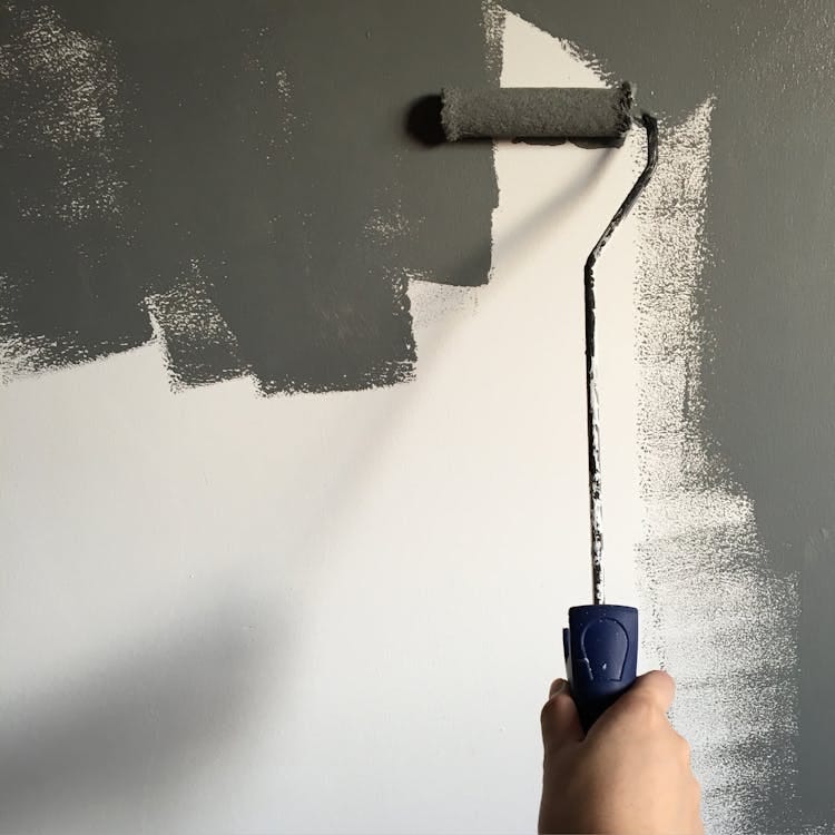 Free A hand painting a wall gray with a roller during a house renovation project. Stock Photo