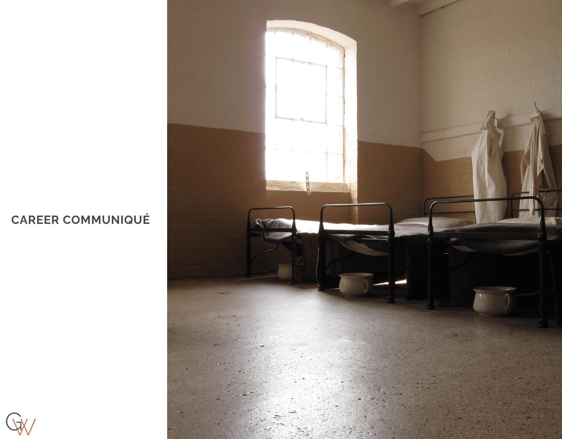 The interior of a Victorian workhouse ward: three iron-framed beds in a row, chamber pots on a bare concrete floor, white garments hanging from hooks on the wall, and a single barred window casting pale light into an otherwise empty room. The interior of a Victorian workhouse ward: three iron-framed beds in a row, chamber pots on a bare concrete floor, white garments hanging from hooks on the wall, and a single barred window casting pale light into an otherwise empty room.