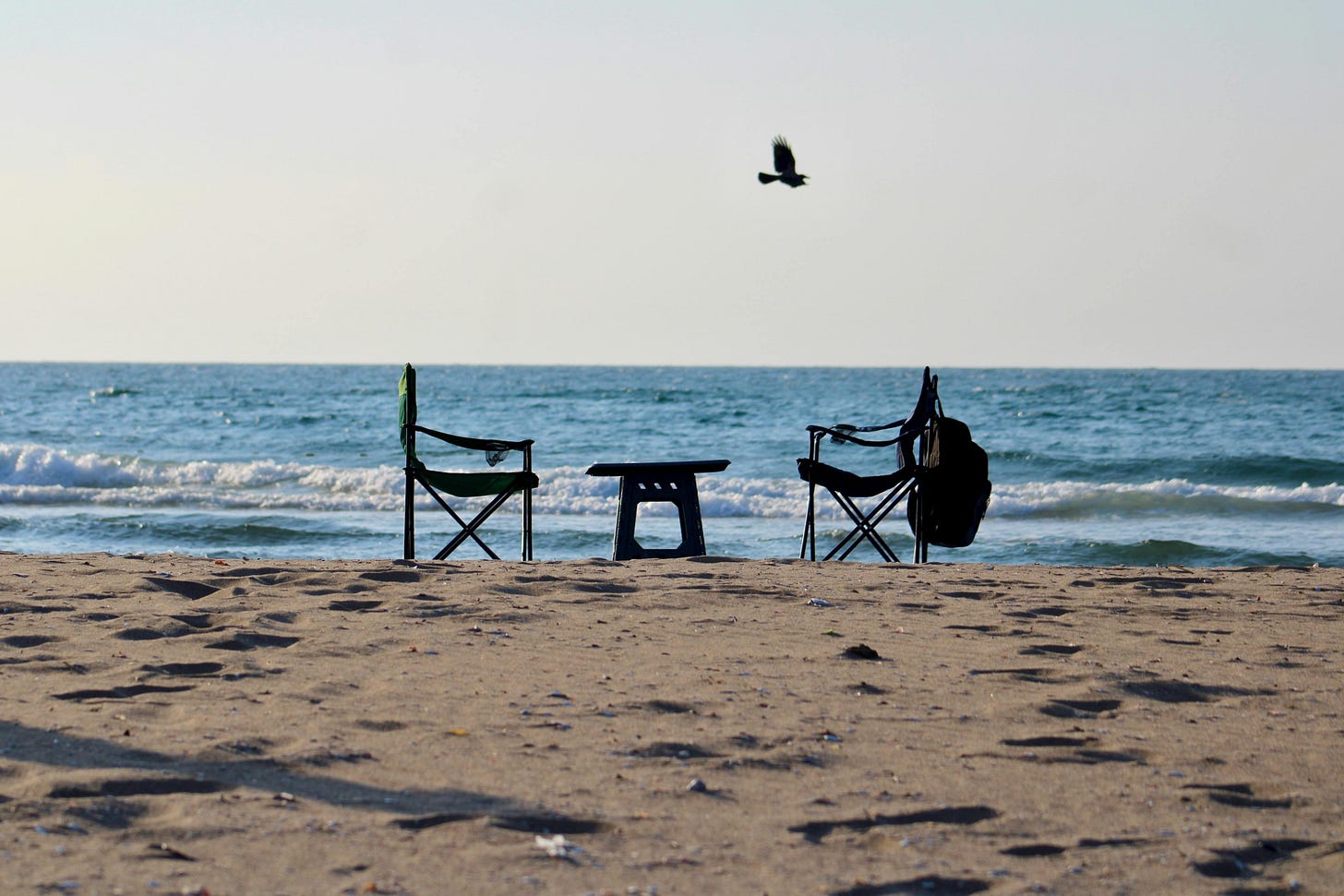 Empty beach chairs facing the serene ocean with waves breaking gently on a sunny day Empty beach chairs facing the serene ocean with waves breaking gently on a sunny day