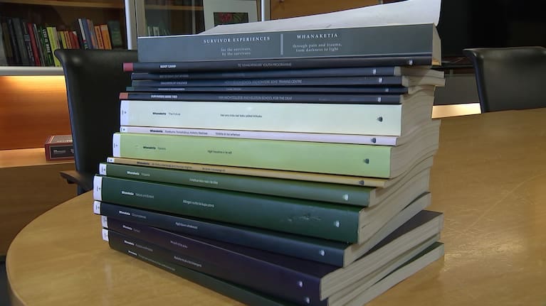 Physical copies of volumes of the report of the Abuse in Care inquiry.