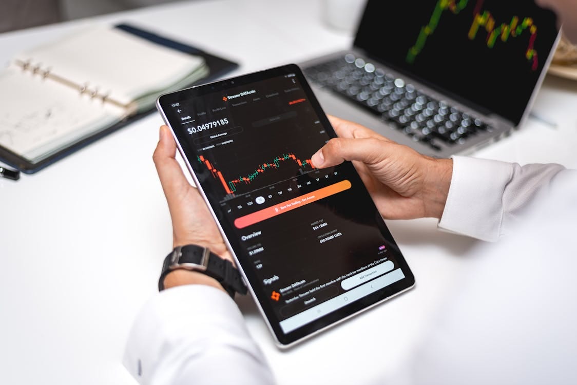 Free Professional analyzing cryptocurrency market data on a digital tablet with financial graphs. Stock Photo