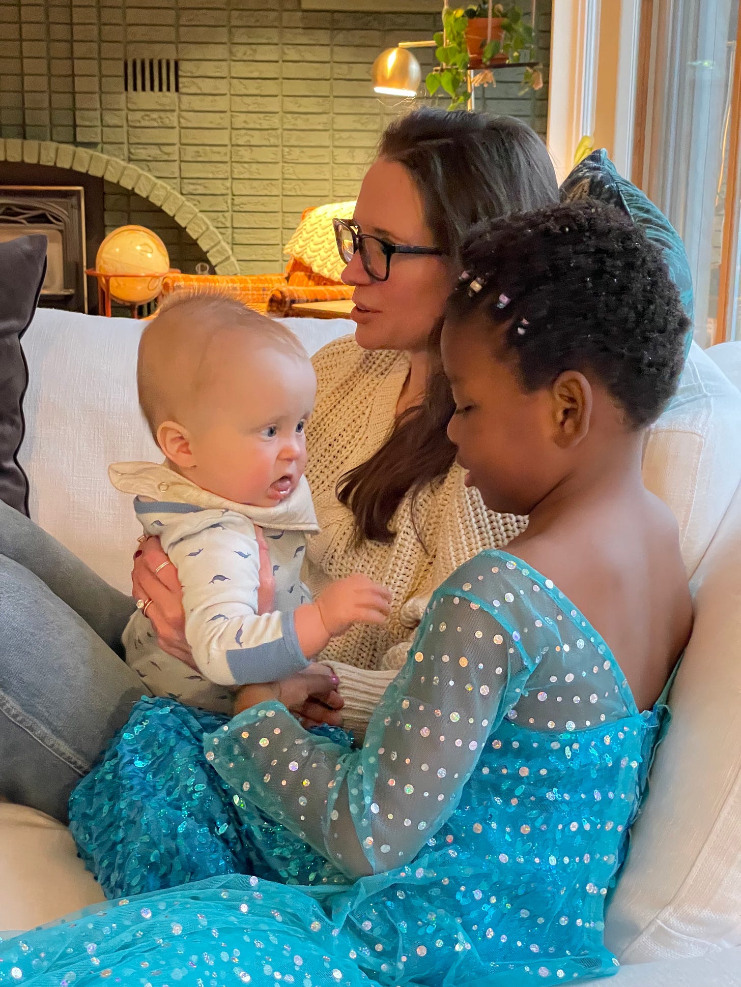 a white woman, white baby, Black kid cuddle