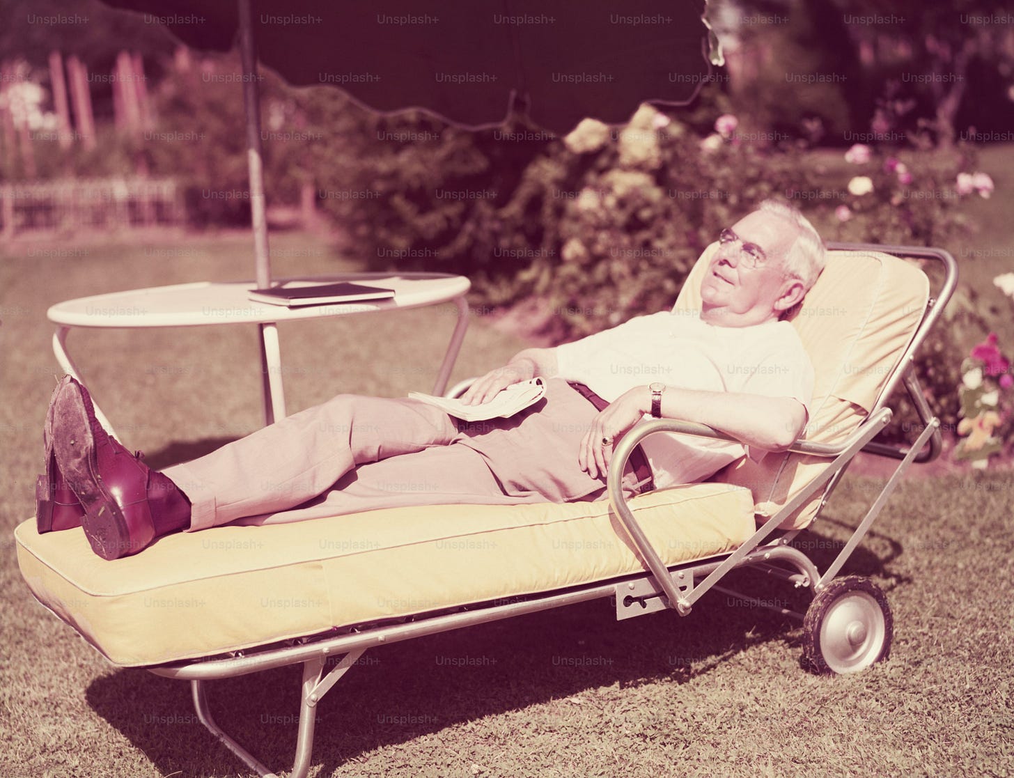 ÉTATS-UNIS - Circa 1950s : Homme âgé se détendant sur une chaise longue dans l’arrière-cour.