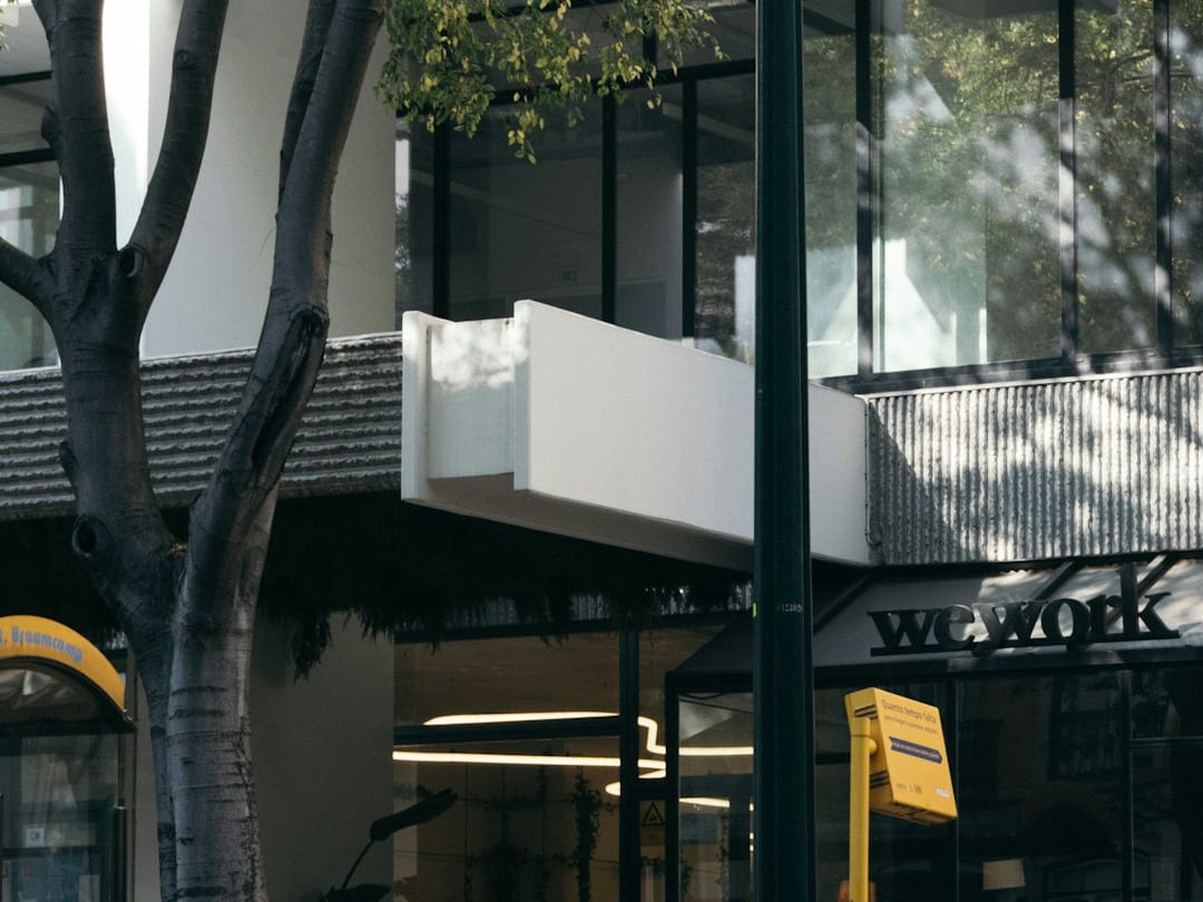 a man walking down a street next to a tall building a man walking down a street next to a tall building