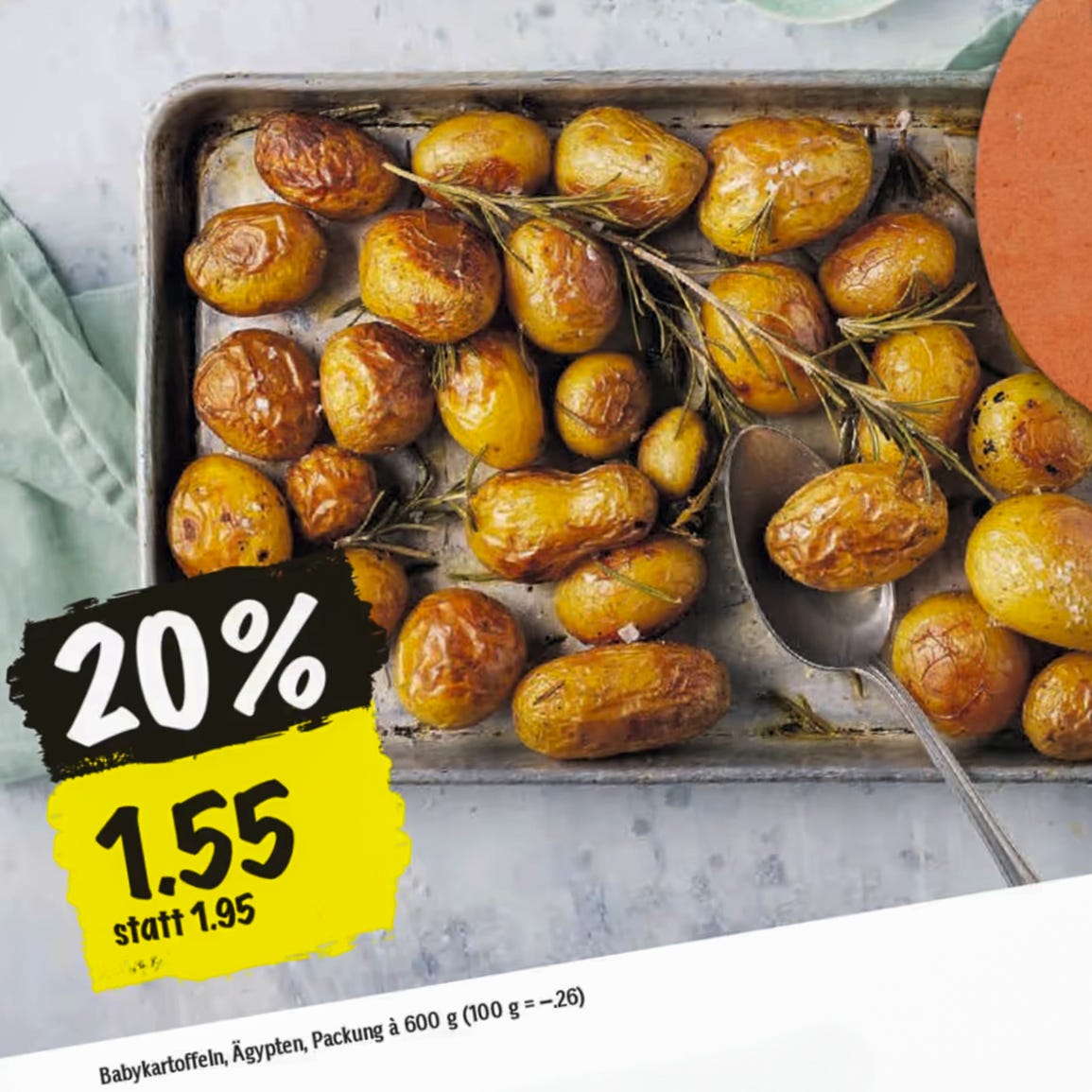 Das Bild zeigt die Werbeanzeige eines Schweizer Detailhändlers für Frühkartoffeln aus Ägypten. Auf einem Backblech liegen goldbraun geröstete Babykartoffeln, garniert mit frischem Rosmarin. Die Anzeige bewirbt die Kartoffeln mit einem Rabatt von 20 Prozent, wodurch der Preis von 1.95 Franken auf 1.55 Franken pro 600 Gramm-Packung reduziert ist. Das Bild zeigt die Werbeanzeige eines Schweizer Detailhändlers für Frühkartoffeln aus Ägypten. Auf einem Backblech liegen goldbraun geröstete Babykartoffeln, garniert mit frischem Rosmarin. Die Anzeige bewirbt die Kartoffeln mit einem Rabatt von 20 Prozent, wodurch der Preis von 1.95 Franken auf 1.55 Franken pro 600 Gramm-Packung reduziert ist.