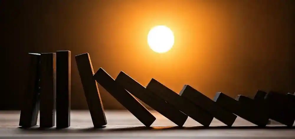 A visual of dominoes falling represents the cascading effects of decompensated cirrhosis and its health complications.