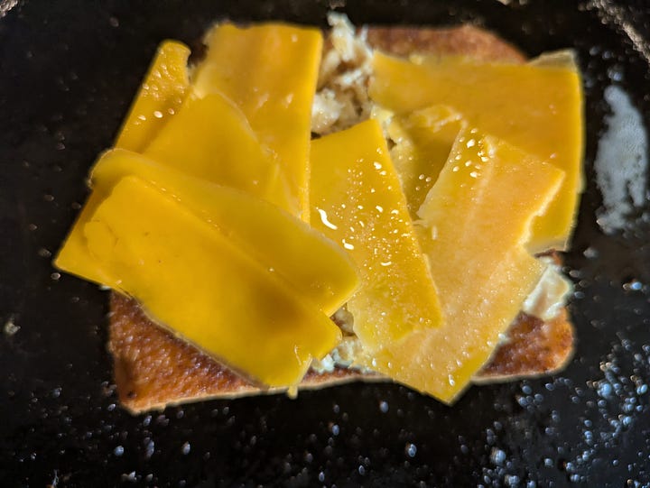 Mixing the tuna and spices, assembling the tuna on toast to melt cheese on top.