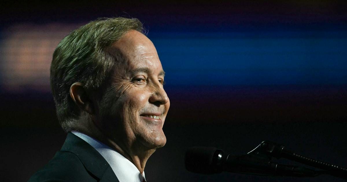 Republican Senate candidate Ken Paxton smiles at a podium