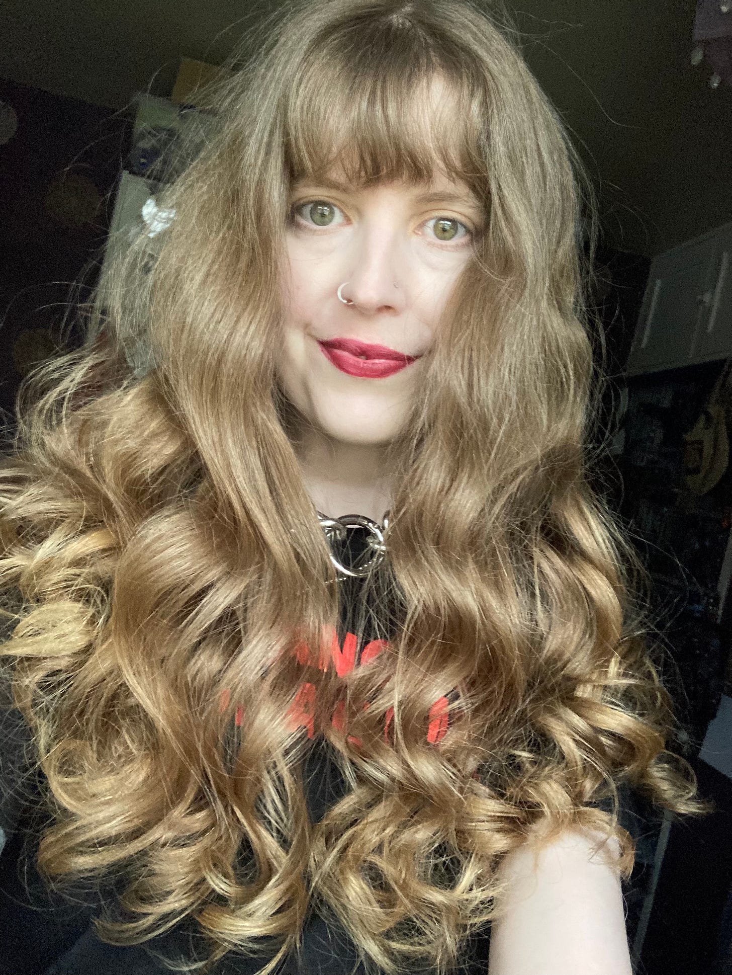 The writer looks at the camera. Their blonde hair is curled and they are smiling. 