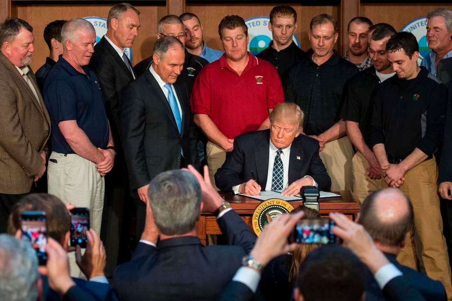 Circondato dai minatori della Rosebud Mining Company, il presidente Trump firma l'ordine esecutivo per l'indpendenza energetica presso la sede dell'EPA a Washington, DC il 28 Marzo 2017. 