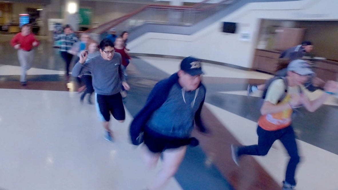 A group of people running in a hallway

AI-generated content may be incorrect.