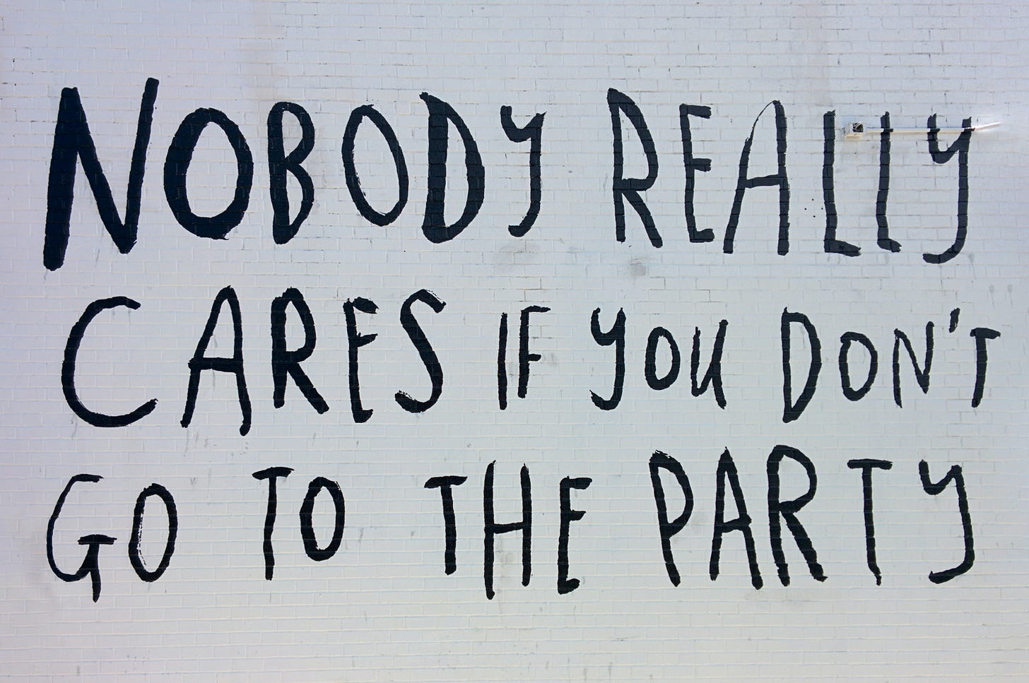 handwritten text on a wall that reads nobody cares if you don't go to the party