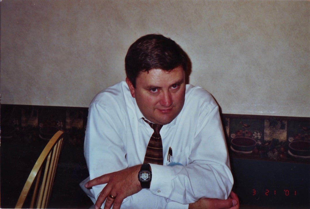 A man in a white dress shirt and tie sits at a table A man in a white dress shirt and tie sits at a table