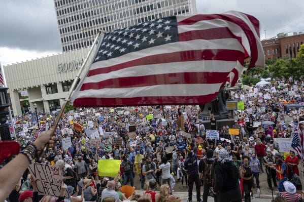 A person waves an American flag as demonstrators gather at Metro Hall during a "No Kings" protest on Saturday, June 14, 2025, in Louisville, Ky. (AP Photo/Jon Cherry) A person waves an American flag as demonstrators gather at Metro Hall during a "No Kings" protest on Saturday, June 14, 2025, in Louisville, Ky. (AP Photo/Jon Cherry)