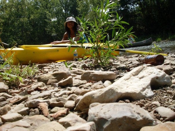 Danver inside yellow kayak above rocky shore on Harpeth river.