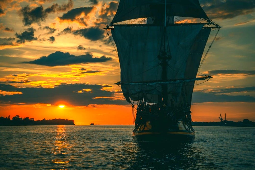 silhouette of ship on sea during sunset