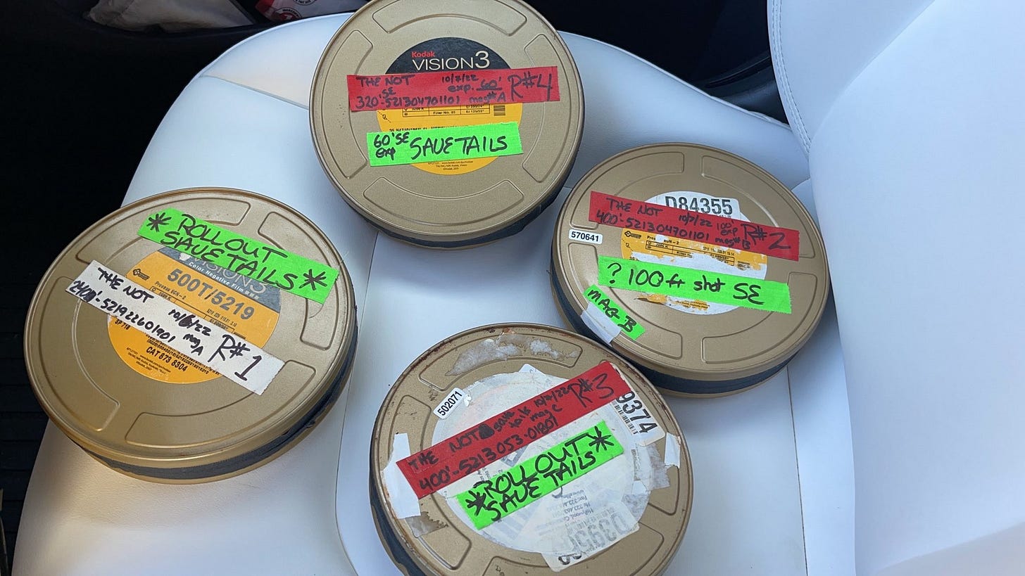 four cans of unprocessed film sitting on the seat of a car on their way to the lab for processing