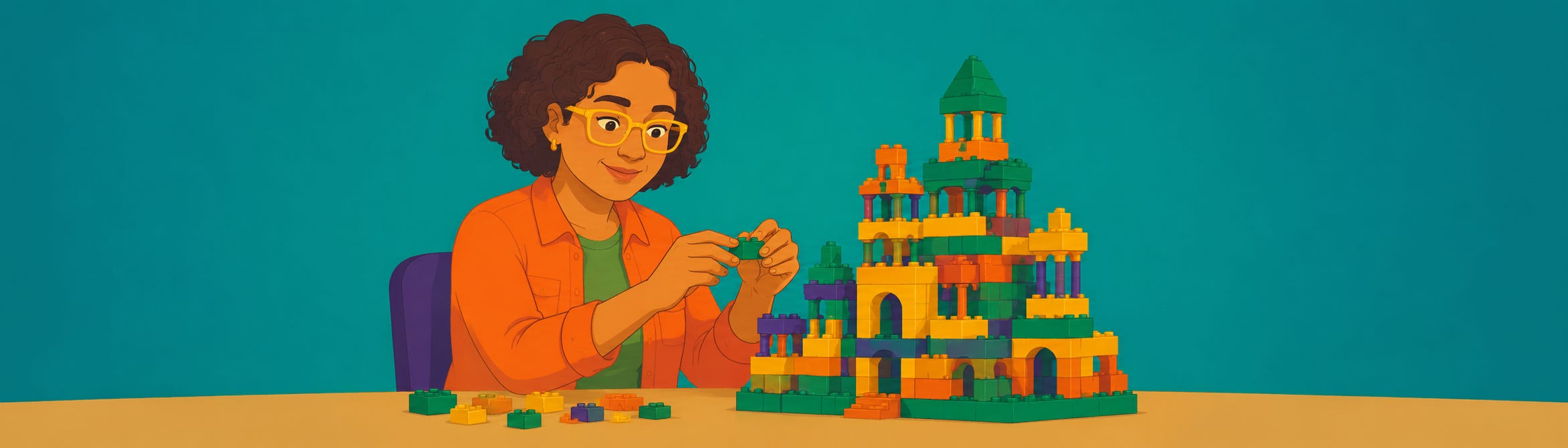 A smiling woman wearing yellow glasses builds an elaborate, colorful toy brick castle at a desk.  
