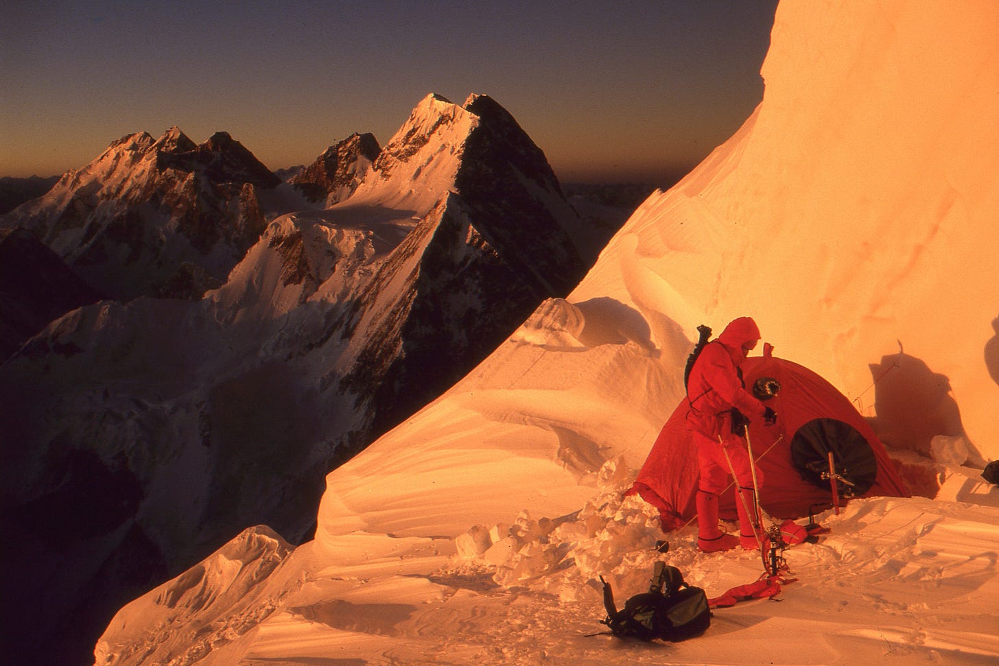 tent on small snow platform, with climbers