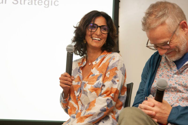 Two people holding microphones, laughin