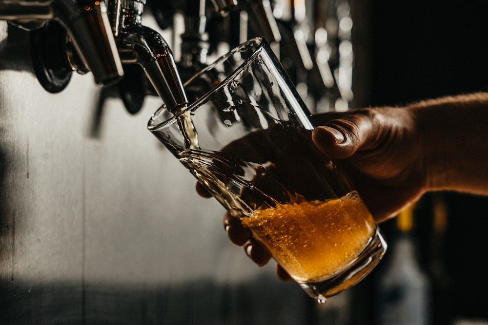 Closeup of a hand pouring a pint of lager Closeup of a hand pouring a pint of lager