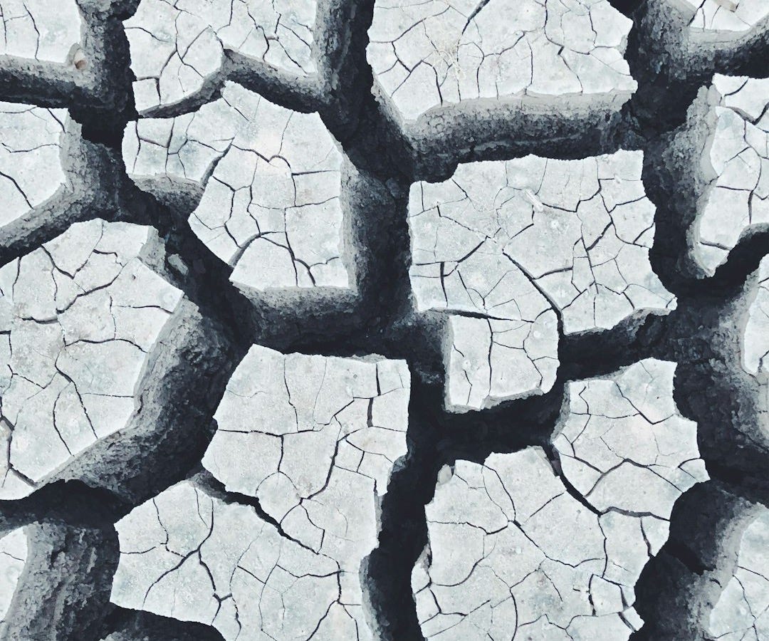 a person standing in the middle of a cracked road a person standing in the middle of a cracked road
