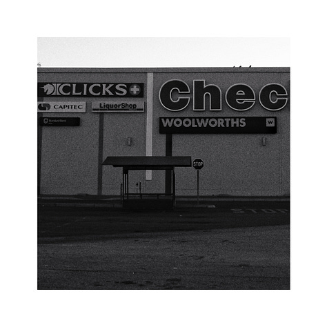 Three black and white images. A flag, a bus stop and a sign.