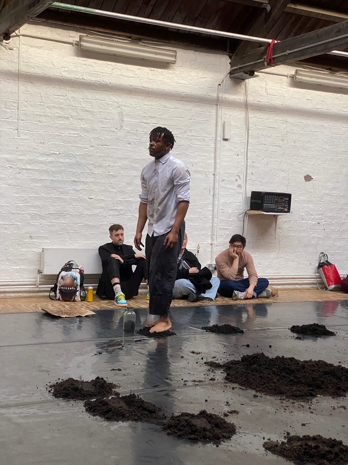 man with short dreadlocks walking on earth in a studio